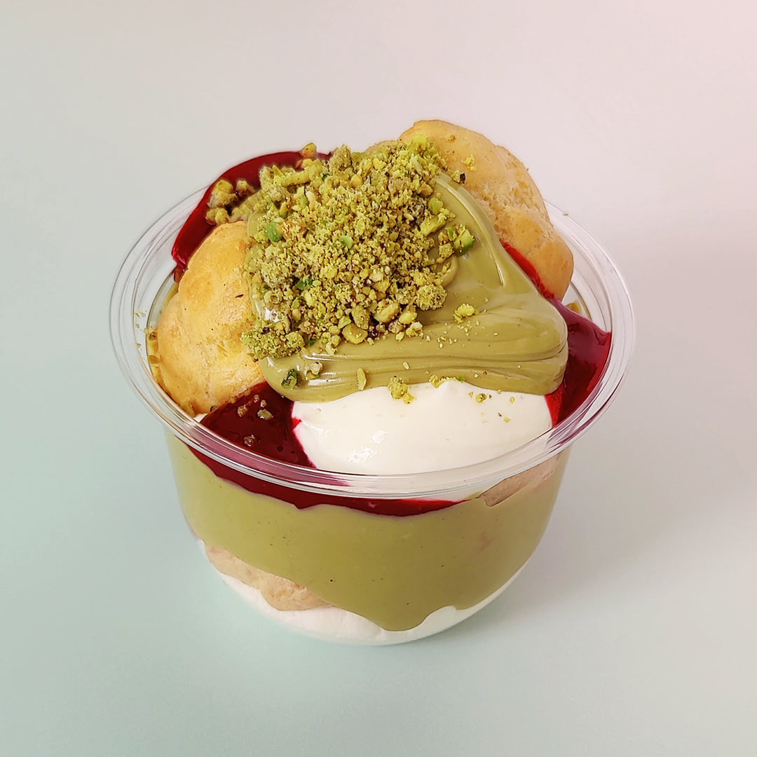 Freshly baked choux bun with pistachio and raspberry flavours. Filled with vanilla creme patissiere smothered with pistachio cream and  homemade  raspberry compote. Delivery available across London. Comes in a handy cup and a generous portion. Order online at Punk Cake or on Uber Eats or Deliveroo